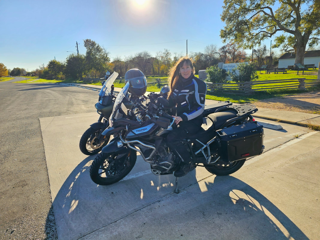 woman sitting on her motorcycle wearing gryphon motorcycle gear smiling